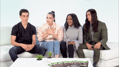 People Sitting On Couch With Entertainment Magazine GIF