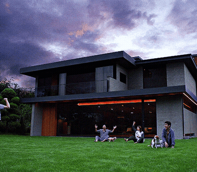 People Sitting On Grass By Large House GIF