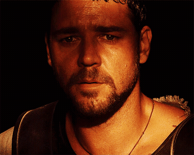 People Standing Around Podium With Man In Gold Vest GIF