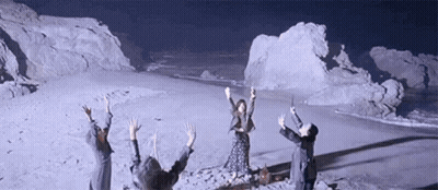 People Standing On Snowy Field With Arms Up GIF