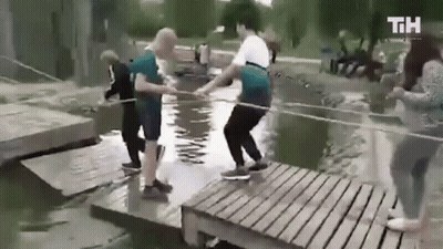People Standing On Wooden Bridge Over River GIF