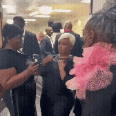 People Talking In Hallway Woman With Pink Flower GIF