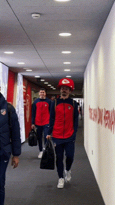 People Walking Down A Hallway With A Sign On The Wall That Says Welcome GIF