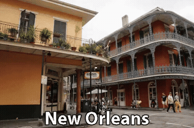 People Walking In Front Of Building Saying New Orleans GIF