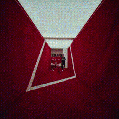 People Walking In Hallway With Coca Cola Mural GIF