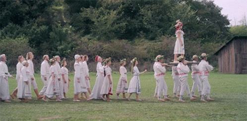 People Walking In Line With Woman On Pole GIF