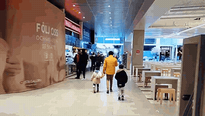 People Walking In Mall With Folioss Sign GIF