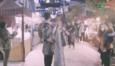 People Walking Past Cinetv.com Sign GIF