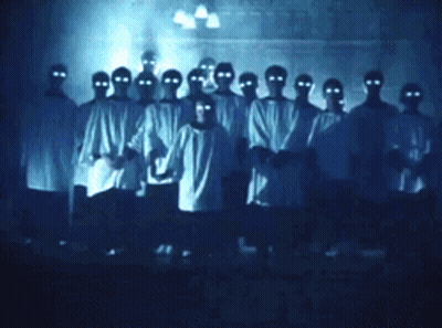People With Glowing Eyes In Dark Room GIF