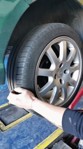 Person Adjusting Tire With Peugeot Logo