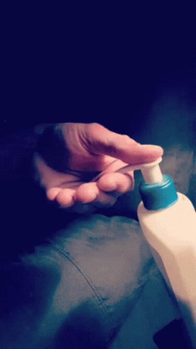 Person Applying Lotion With Blue Cap