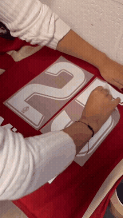 Person Applying Stickers To Red Shirt With 20 GIF