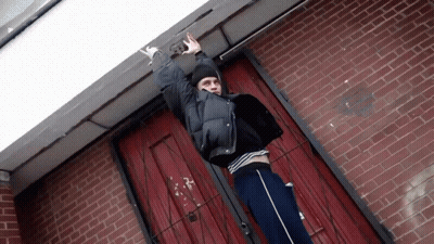 Person At Brick Building Number 38 GIF