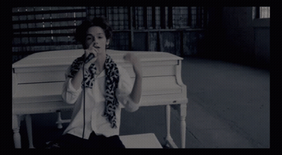 Person At White Piano With Scarf Saying SKS GIF