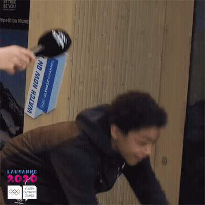 Person Being Interviewed In Front Of Watch Now Sign GIF