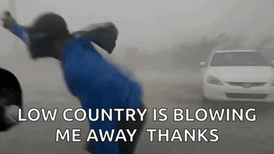 Person Blowing in Wind in Front of Car