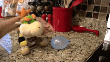 Person Blowing Up Stuffed Animal On Kitchen Counter GIF