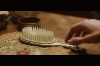 Person Brushing Hair With Silver Brush GIF
