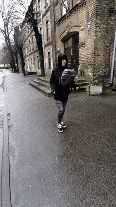 Person Carrying Baby In Sling On Street GIF