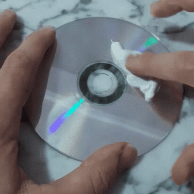 Person Cleaning CD With Tissue And Toothbrush GIF
