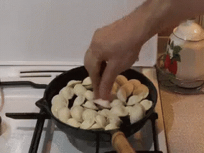 Person Cooking Food In Pan On Stove GIF