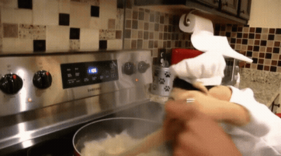 Person Cooking On Samsung Stove With Paper Towel GIF