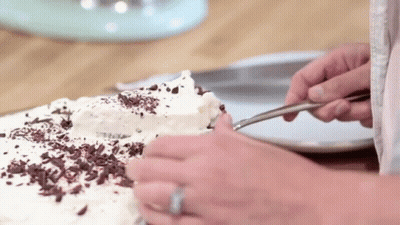 Person Cutting Cake With Chocolate Shavings GIF
