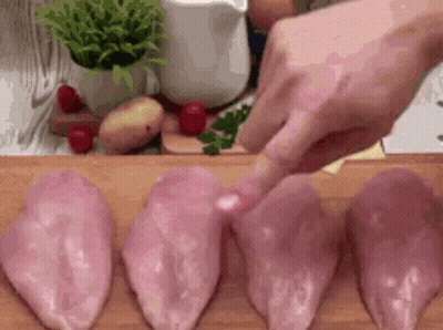 Person Cutting Chicken Breasts On Cutting Board GIF