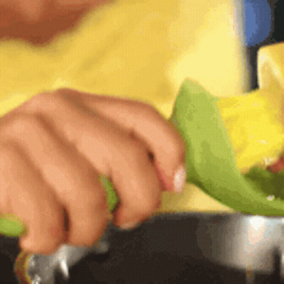 Person Cutting Corn With Green Knife GIF