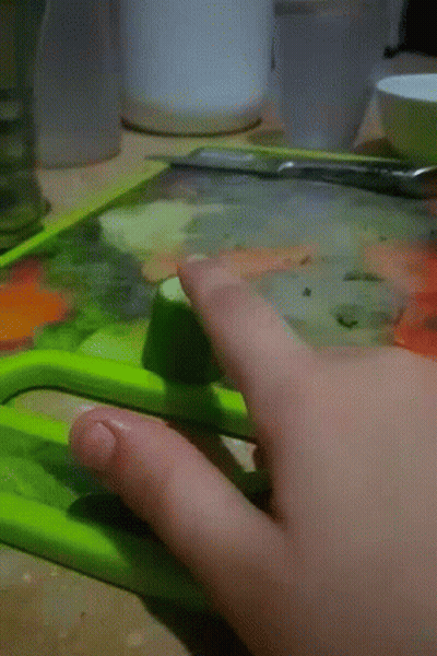 Person Cutting Cucumber With Green Knife