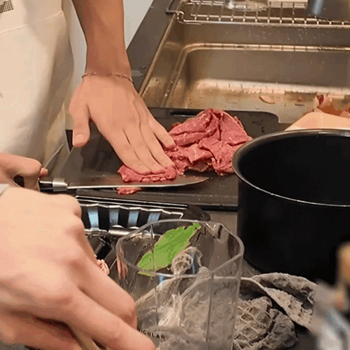 Person Cutting Meat Next To Measuring Cup GIF