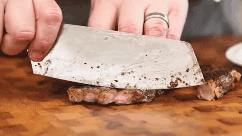 Person Cutting Meat With Large Knife GIF
