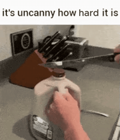 Person Cutting Milk Bottle With Knife In Kitchen GIF