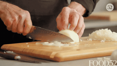 Persona cortando cebolla en tabla Food52 GIF