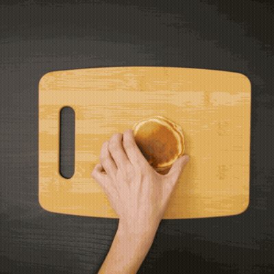Person Cutting Pancake On Wooden Board GIF
