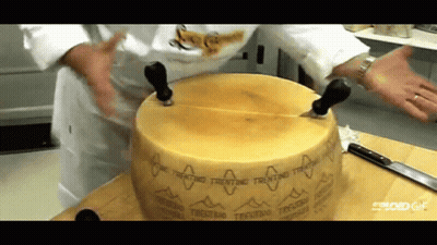 Person Cutting Trentino Cheese On Cutting Board GIF