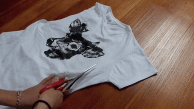 Person Cutting White Shirt With Wolf Picture GIF