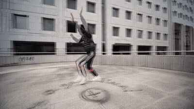 Person Dancing In Front Of Building With Black Text GIF