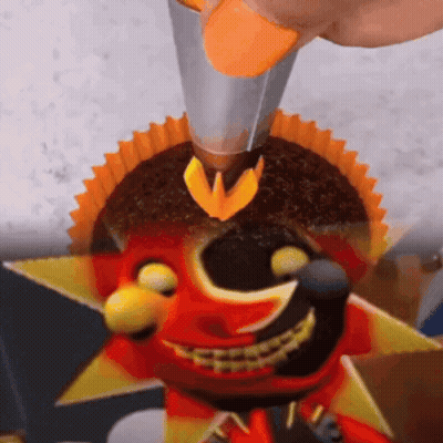 Person Decorating Cupcake With Smiley Face GIF
