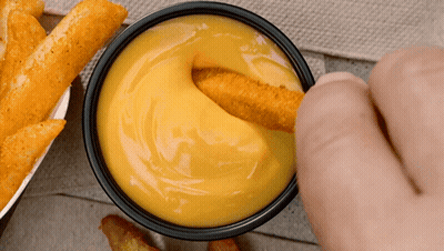 Person Dipping Chicken Nugget In Bowl Of Cheese Sauce GIF