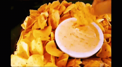 Person Dipping Chip Into Cheese Sauce GIF