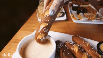 Person Dipping Pretzel In Sauce GIF