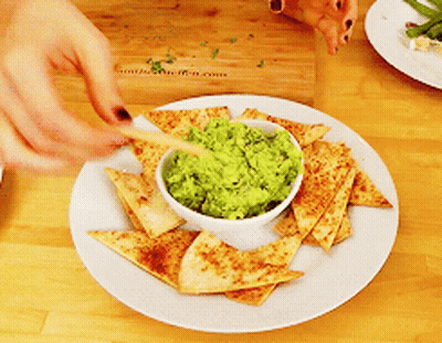 Person Dipping Tortilla Chip Into Guacamole GIF