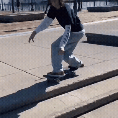 Person Doing Skateboard Trick On Sidewalk GIF