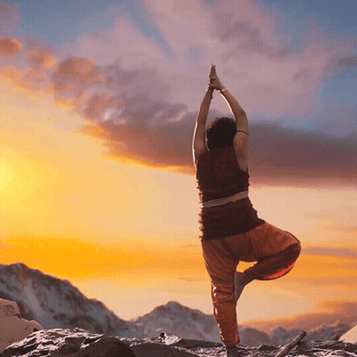 Person Doing Yoga Pose In Front Of Mountain At Sunset GIF