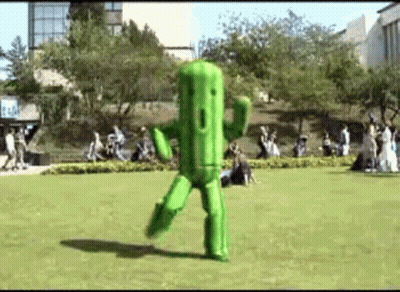 Person Dressed As Green Cactus Dancing In Park GIF