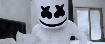 Person Dressed As Marshmello Standing On Bed With Bandaged Arm GIF