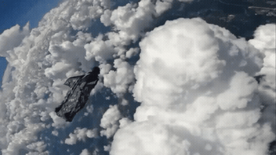Person Flying Through Cloudy Sky With Blanket GIF