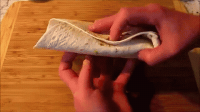Person Folding Tortilla On Cutting Board GIF