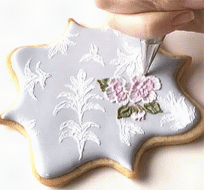 Person Frosting Cookie With White Frosting Bag GIF